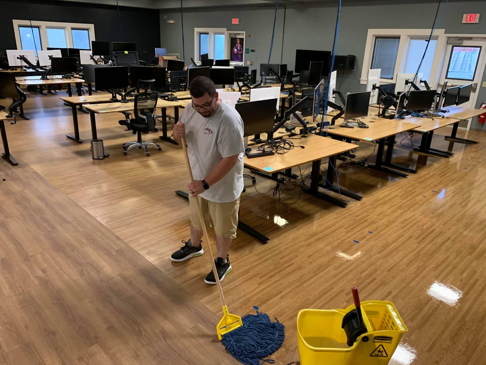 A Truly, Truly Clean team member mopping the floor of an open-plan office